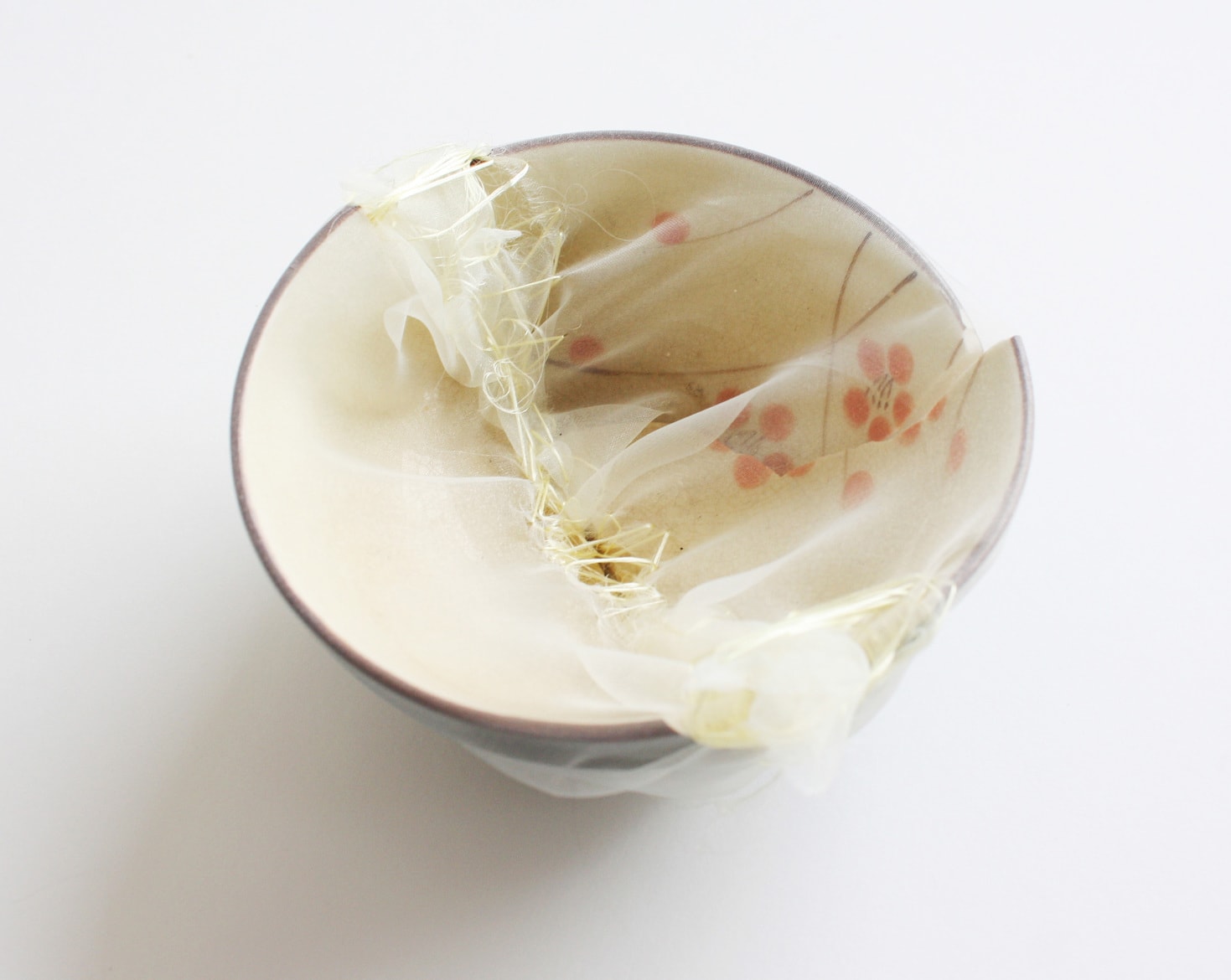‘K.K.'s grand mother's renovated rice bowl’, 2009, ceramic bowl, Italian synthetic cloth, Japanese silk thread, 11D x 5H cm