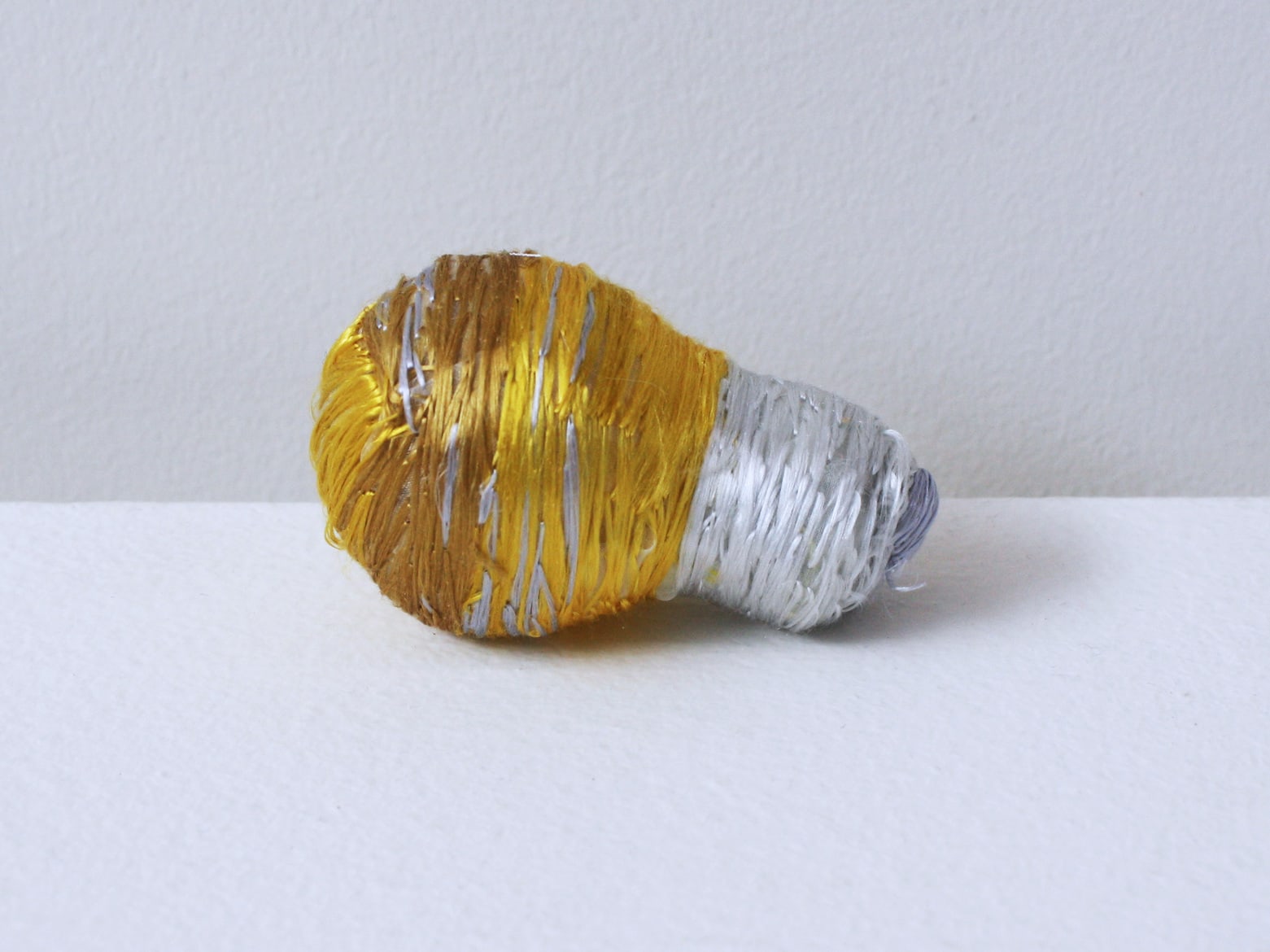 ‘Renovated light bulb yellow’, 2012, light bulb, Italian synthetic cloth, Japanese silk thread, 7H x 4D cm